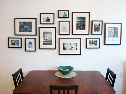 a lovely kitchen wall covered in framed photographs